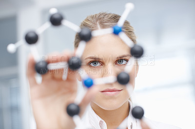 Buy stock photo Closeup of a gorgeous female scientist holding up a molecular structure model