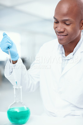Buy stock photo An attractive male scientist adding one chemical to another in the lab
