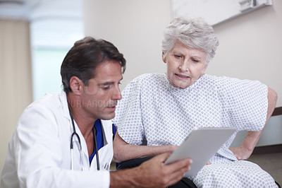 Buy stock photo A male doctor showing his senior patient her medical report on his digital tablet