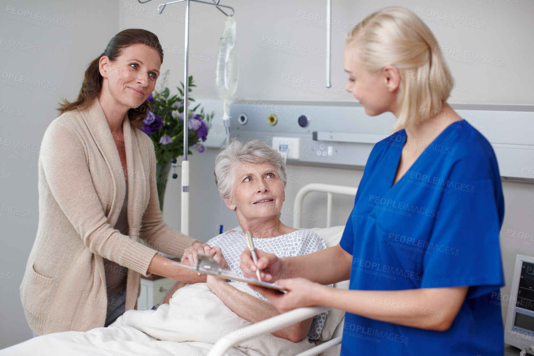 Buy stock photo A happy daughter and her mother filling out a medical form with the help of a young nurse