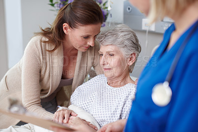 Buy stock photo A daughter consoling her mother in the hospital after talking with the nurse