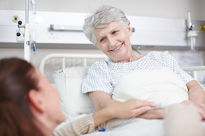 Buy stock photo An affectionate daughter visiting her ill mother in the hospital