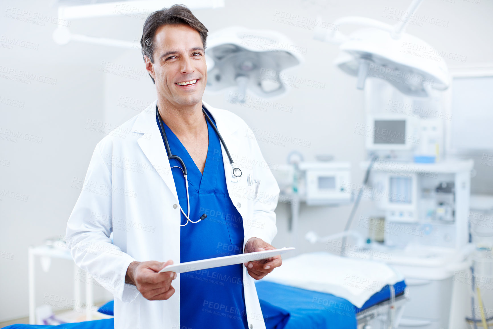 Buy stock photo A happy male doctor holding a chart in the hospital