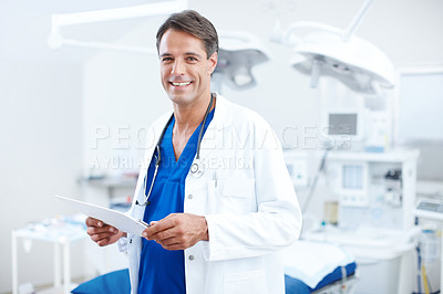 Buy stock photo A confident male doctor holding smiling and holding a chart in the hospital