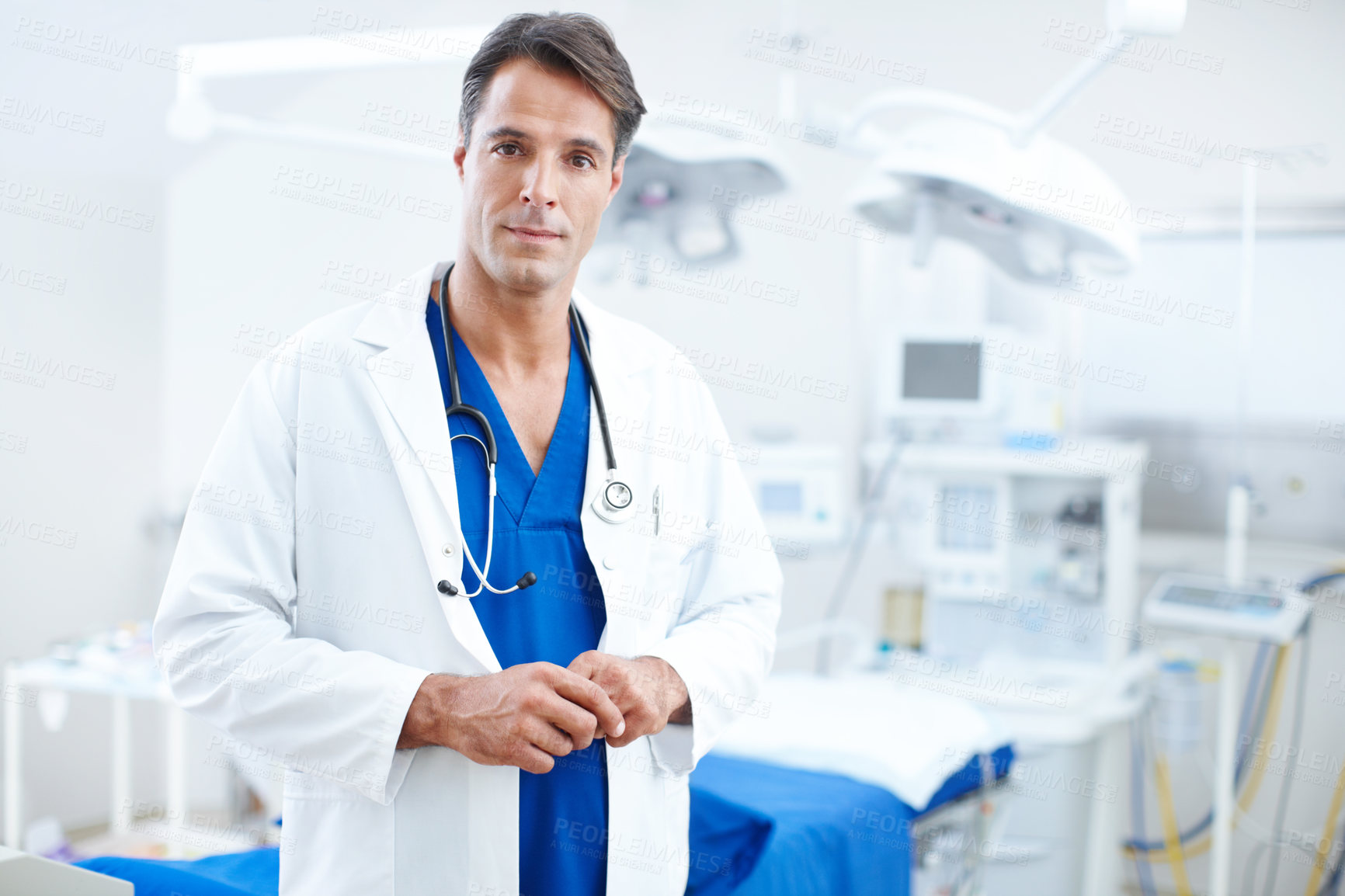 Buy stock photo A confident male doctor standing infront of the operating table in the hospital