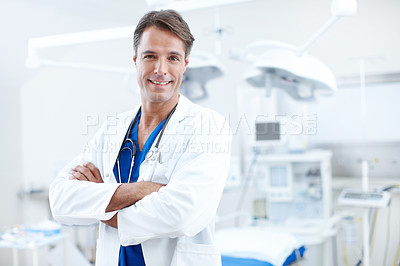 Buy stock photo Close-up of a confident male doctor standing with his arms crossed in the hospital
