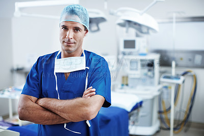 Buy stock photo A handsome doctor standing in scrubs in the operating theatre