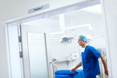 Buy stock photo A doctor walking inside a room marked 
