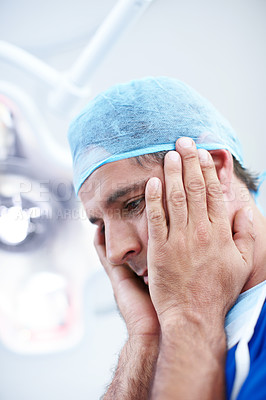 Buy stock photo A helpless looking doctor holding his head in his hands