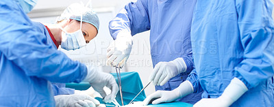 Buy stock photo Profile shot of surgeons working together wearing scrubs in an operating room