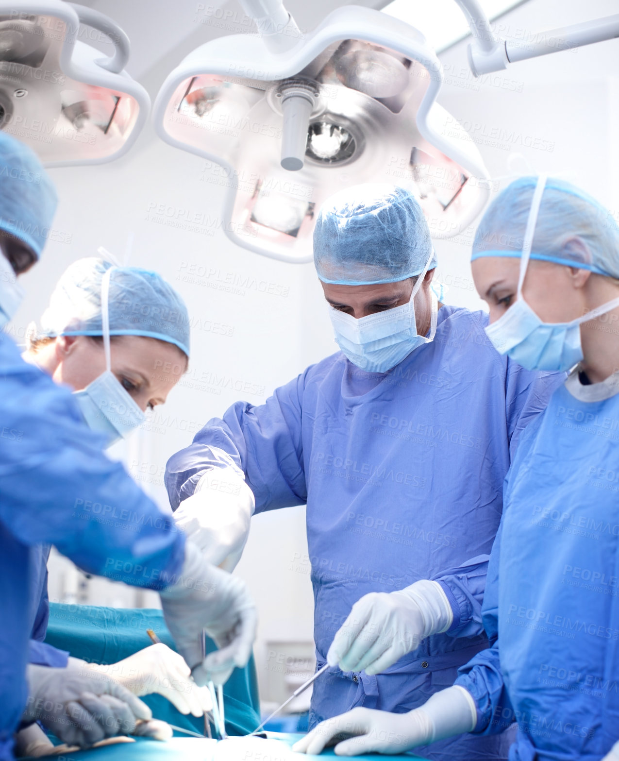 Buy stock photo Surgery, teamwork and doctors in theater together for emergency medical treatment in hospital. People, surgeon and nurses in operating room with equipment, healthcare and group support in trauma unit