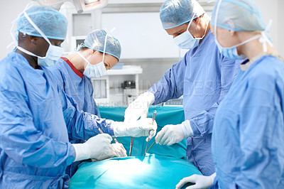 Buy stock photo Group of doctors and surgeons at work in an operating theatre