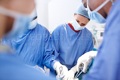 Buy stock photo Group of professional surgeons operating on a patient in surgery