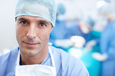 Buy stock photo Closeup portrait of a doctor looking serious with his colleagues operating in the background
