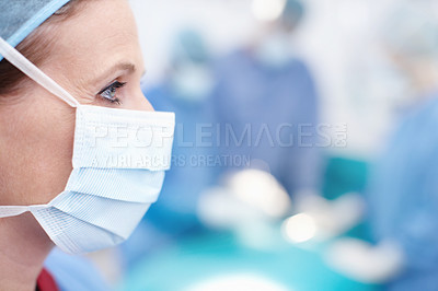 Buy stock photo Side profile of a mature female doctor wearing hospital scrubs and a protective face mask - Copyspace