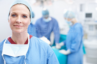 Buy stock photo Portrait of a happy mature woman wearing hospital scrubs in an operating theatre during a surgery