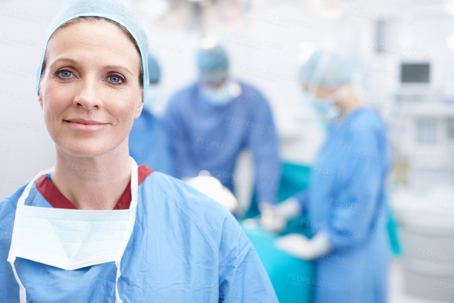 Buy stock photo Portrait of a happy mature woman wearing hospital scrubs in an operating theatre during a surgery