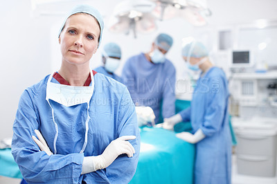 Buy stock photo Portrait of a serious surgical doctor standing with her arms crossed during a surgery