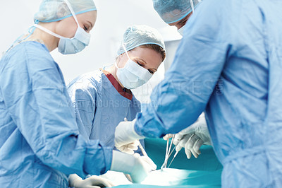 Buy stock photo Surgeons using medical tools and forceps to operate on a patient in surgery