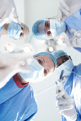 Buy stock photo Patient's view of medical surgeons and doctors operating