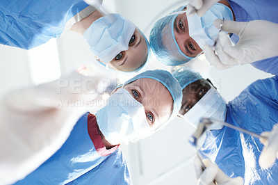 Buy stock photo Surgeons and doctors leaning over the camera holding medical tools as though operating