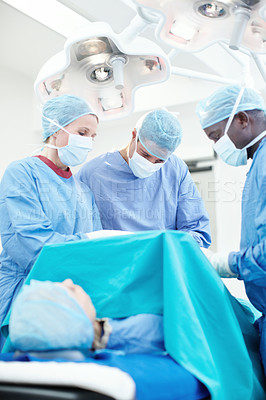 Buy stock photo Diverse medical surgeons operating together on a patient in an ER