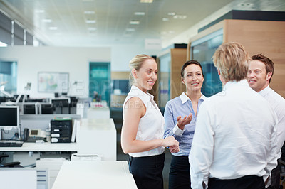 Buy stock photo Business coworkers standing together and chatting while in the office