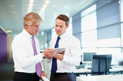 Buy stock photo Handsome business man with colleague using tablet PC in office