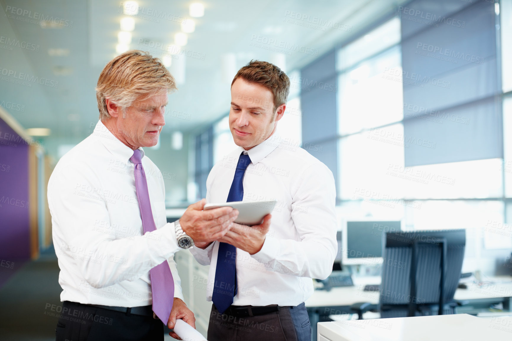 Buy stock photo Handsome business man with colleague using tablet PC in office