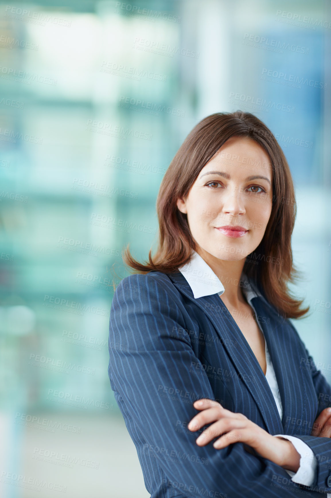 Buy stock photo Portrait of one happy young confident businesswoman standing with arms crossed in office with copyspace. Smiling ambitious entrepreneur and professional leader ready for success in corporate agency