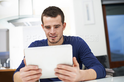 Buy stock photo Home, man and smile with tablet for reading, local news and entertainment on social media in kitchen. House, male person and digital with subscription for online games, ebook and streaming service