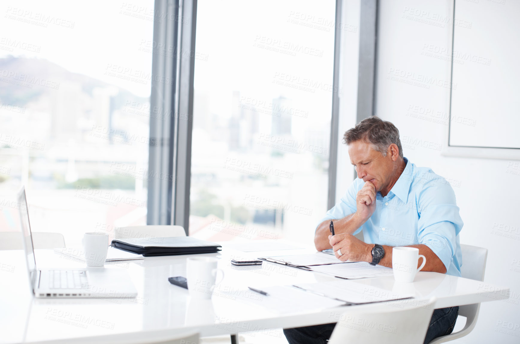 Buy stock photo A mature advertising executive thinking about his next ad campaign