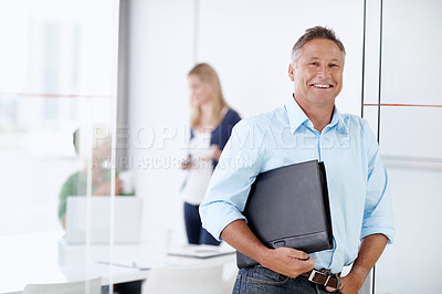 Buy stock photo Portrait of a mature ad executive with his team working behind him