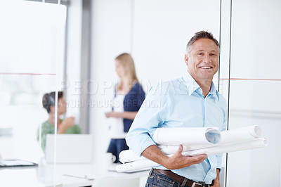 Buy stock photo A mature architect leaning against the door with his colleagues in the background