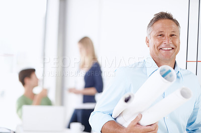 Buy stock photo A mature architect leaning against the door with his colleagues in the background