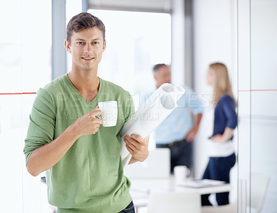 Buy stock photo Portrait of a young architect holding a cup of coffee and his blueprints
