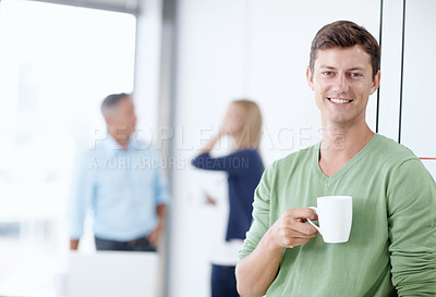 Buy stock photo Portrait of a young man in an office holding a cup of coffee