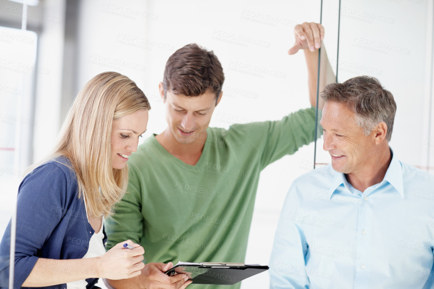 Buy stock photo Three work colleagues discussing something work related