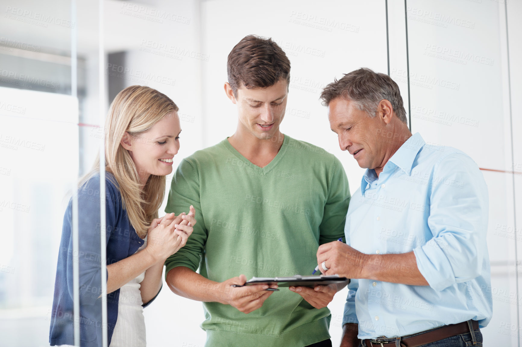 Buy stock photo Three work colleagues discussing something work related