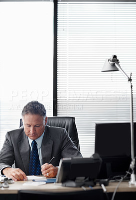 Buy stock photo A senior businessman working hard at his desk - Copyspace