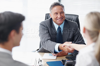 Buy stock photo A manager shaking hands with a female colleague in his office