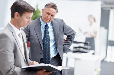 Buy stock photo A senior executive looking over a younger colleague's notes - Copyspace