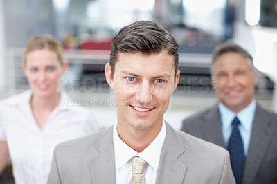 Buy stock photo Portrait of an ambitious executive with colleagues standing behind him