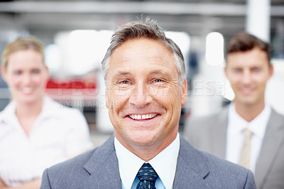 Buy stock photo Portrait of an experienced executive with his colleagues standing behind him