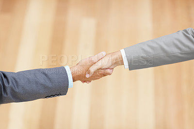 Buy stock photo Cropped image of two executives shaking hands amidst copyspace