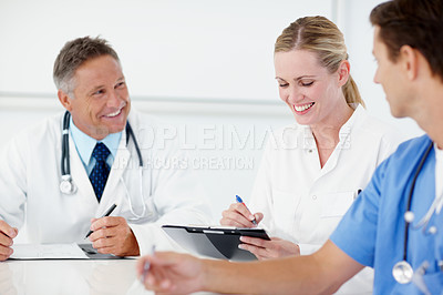 Buy stock photo Three medical professionals having a catch up meeting together