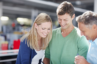 Buy stock photo Three work colleagues discussing something work related