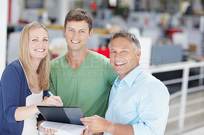 Buy stock photo Portrait of a team of office workers going over paperwork on a clipboard