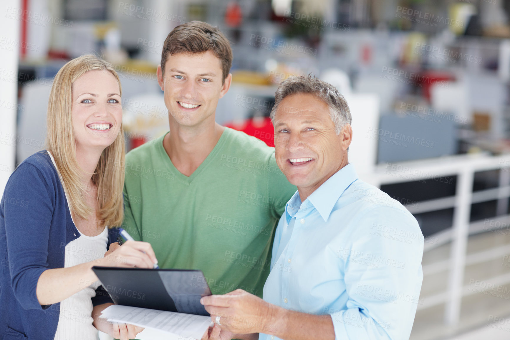 Buy stock photo Portrait of a team of office workers going over paperwork on a clipboard