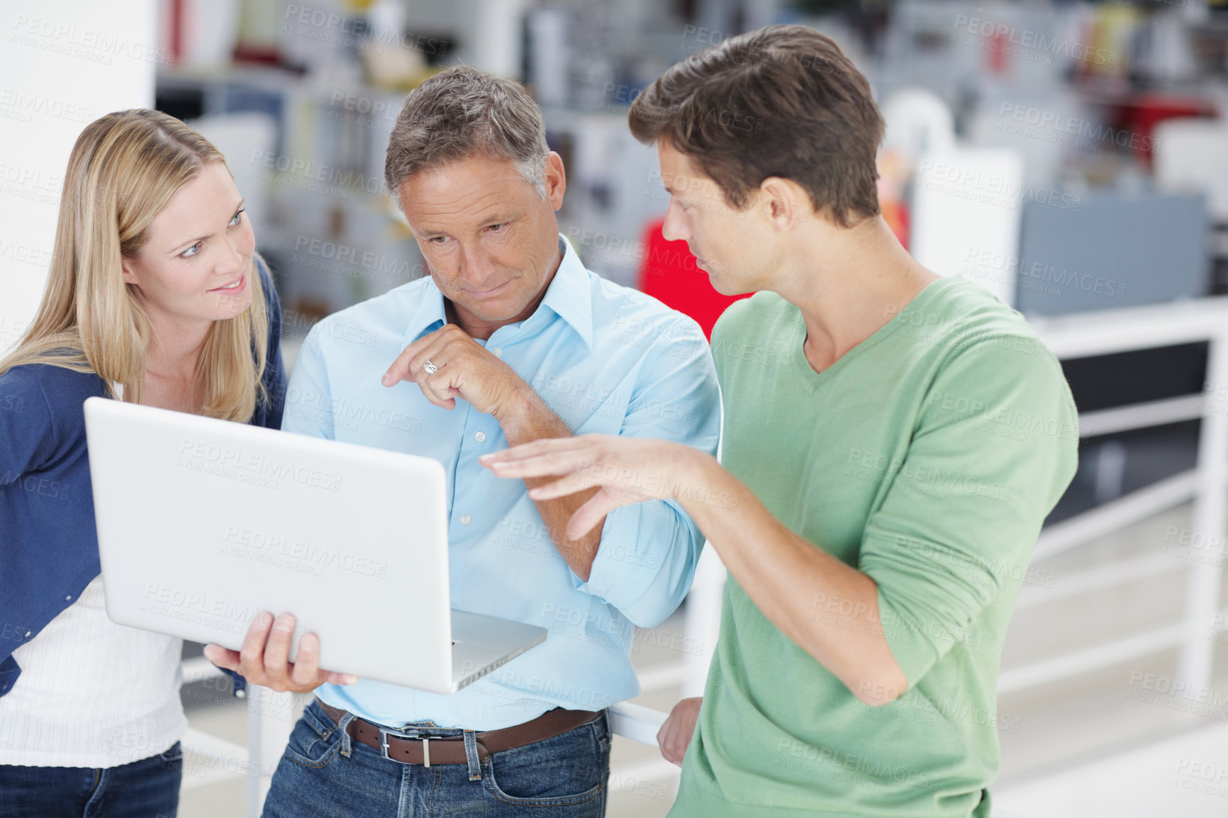 Buy stock photo Three work colleagues working on laptop at the office